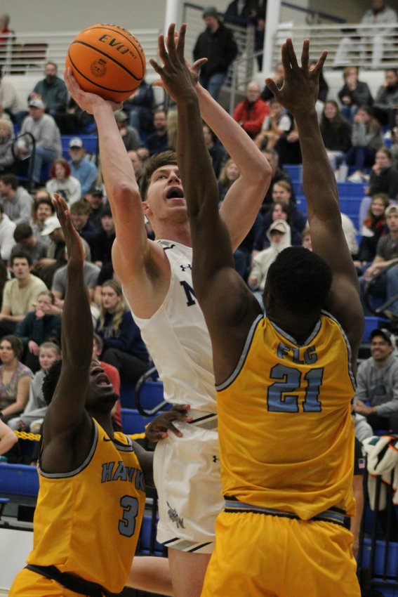 Mines senior forward Adam Thistlewood, center, attempts a second-half jumpshot over Fort Lewis defenders during the Jan. 27 game at Colorado School of Mines.